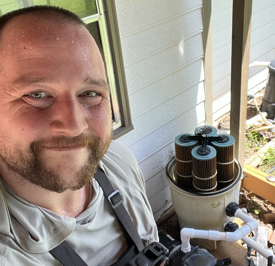 Scotty, owner of Streamline Pools, servicing a pool filter